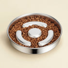 CloudSleep Slow Feeder Bowl — stainless steel bowl with three curved baffles and a central post, filled with kibble.
