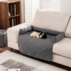 Alfombrilla impermeable para mascotas CloudSleep – perro tumbado en un sofá protegido por la alfombrilla acolchada, con cojines alrededor