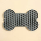Alfombra gris para lamer en forma de hueso, con textura de panal y orificio para colgar.