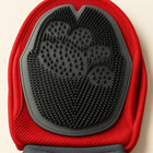Close-up of the grooming mitten’s dark silicone palm and red fabric edge.