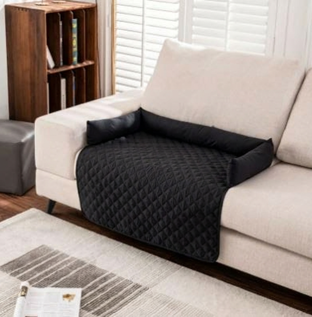 Alfombrilla impermeable para mascotas CloudSleep – alfombrilla acolchada negra sobre un sofá blanco en un salón